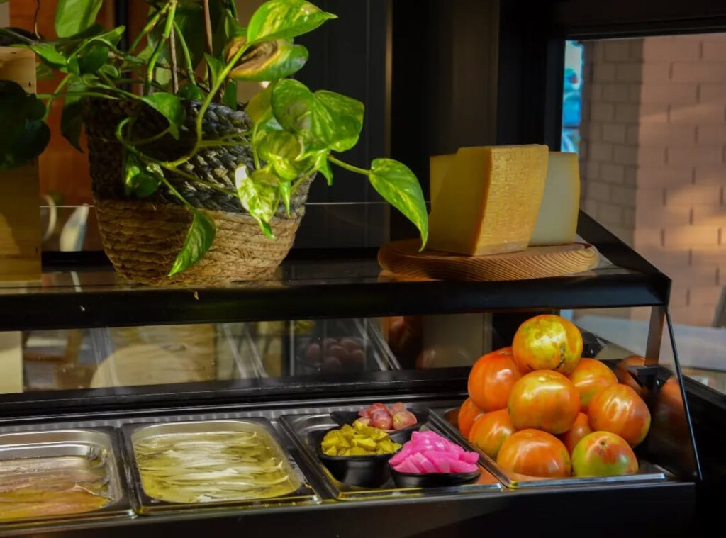 La barra con el mostrador que contiene boquerones, anchoas, encurtidos, quesos, tomates..